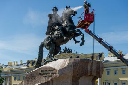 Санкт-Петербург. Работник музея Городской скульптуры моет памятник Петру I `Медный всадник` на Сенатской площади.