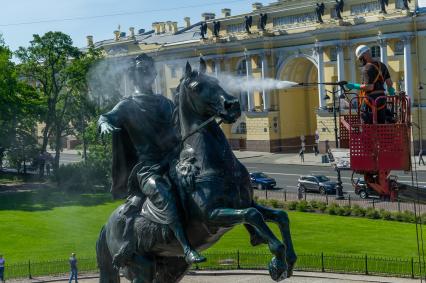 Санкт-Петербург. Работник музея Городской скульптуры моет памятник Петру I `Медный всадник` на Сенатской площади.