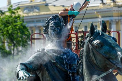 Санкт-Петербург. Работник музея Городской скульптуры моет памятник Петру I `Медный всадник` на Сенатской площади.