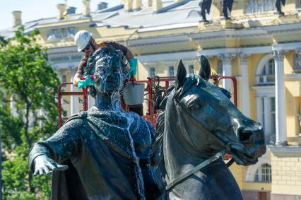 Санкт-Петербург. Работник музея Городской скульптуры моет памятник Петру I `Медный всадник` на Сенатской площади.