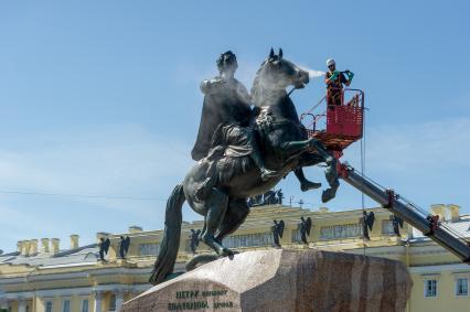 Санкт-Петербург. Работник музея Городской скульптуры моет памятник Петру I `Медный всадник` на Сенатской площади.