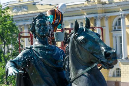 Санкт-Петербург. Работник музея Городской скульптуры моет памятник Петру I `Медный всадник` на Сенатской площади.