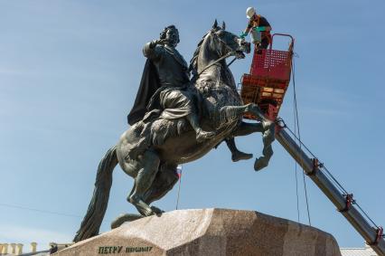 Санкт-Петербург. Работник музея Городской скульптуры моет памятник Петру I `Медный всадник` на Сенатской площади.