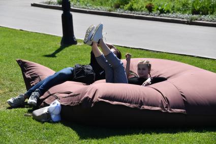 Москва. Молодые люди отдыхают на надувных подушках в Парке Горького.