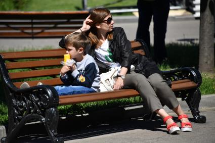 Москва. Женщина с ребенком отдыхает на скамейке в Парке Горького.