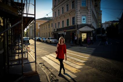 Москва. Девушка идет по пешеходному переулку в Хлебном переулке.