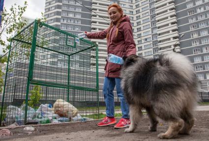 Пермь. Девушка выбрасывает мусор в контейнер для раздельного сбора пластиковых бутылок.