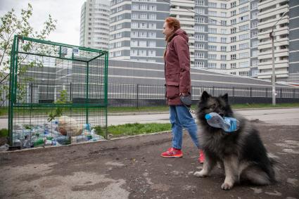 Пермь. Девушка выбрасывает мусор в контейнер для раздельного сбора пластиковых бутылок.