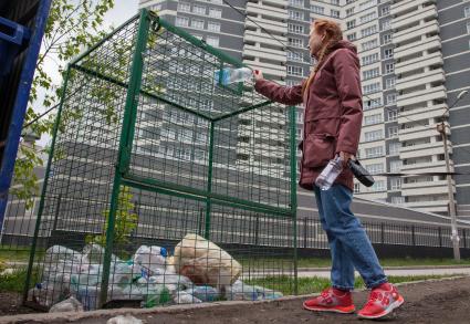 Пермь. Девушка выбрасывает мусор в контейнер для раздельного сбора пластиковых бутылок.