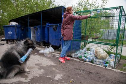 Пермь. Девушка выбрасывает мусор в контейнер для раздельного сбора пластиковых бутылок.