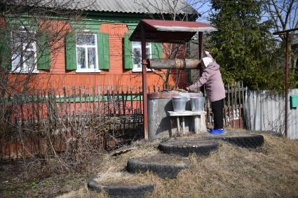 Балашов. Местная жительница берет  воду из колодца.