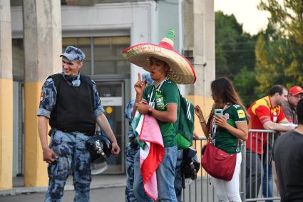 Москва. Болельщик чемпионата мира по футболу 2018  общается с сотрудником полиции.