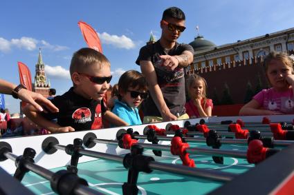 Москва. Посетители в Парке футбола ЧМ-2018 на Красной площади играют в настольный футбол.