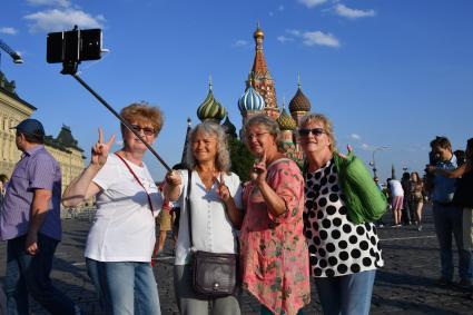 Москва.  Женщины фотографируются на Красной площади.