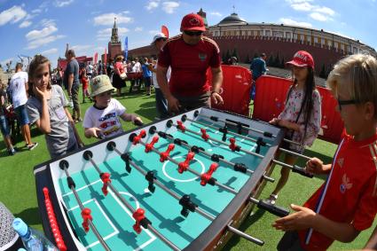 Москва. Посетители играют в настольный футбол в парке футбола чемпионата мира 2018 на Красной площади.