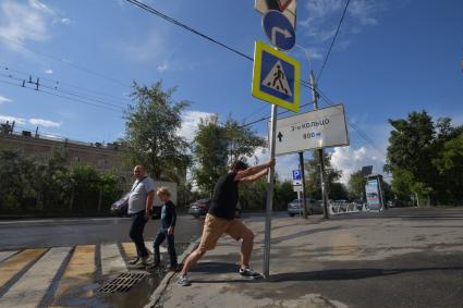 Москва. Корреспондент `Комсомольской правды` Павел Клоков тестирует дорожный знак на гибкой стойке, который при столкновении остается на месте и принимает прежнюю форму.