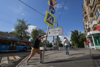 Москва. Корреспондент `Комсомольской правды` Павел Клоков тестирует дорожный знак на гибкой стойке, который при столкновении остается на месте и принимает прежнюю форму.