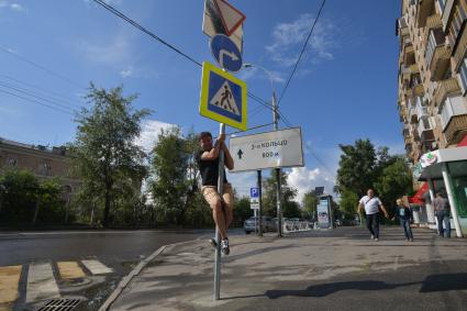 Москва. Корреспондент `Комсомольской правды` Павел Клоков тестирует дорожный знак на гибкой стойке, который при столкновении остается на месте и принимает прежнюю форму.