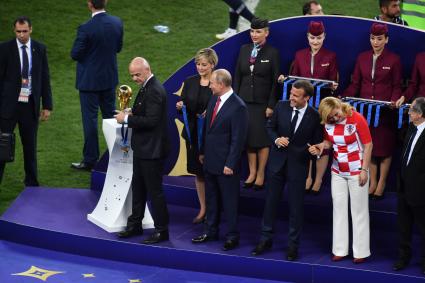 Москва. Президент FIFA Джанни Инфантино, президент РФ Владимир Путин, президент Франции Эммануэль Макрон и президент Хорватии Колинда Грабар-Китарович (слева направо на первом плане) во время церемонии награждения после финального матча чемпионата мира по футболу - 2018 между сборными командами Франции и Хорватии на стадионе `Лужники`.