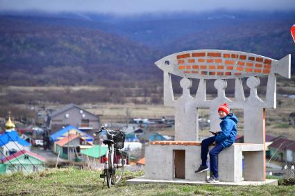 Остров Итуруп, Курильск. Мальчик с велосипедом у одного из арт-объектов, украшающих город и его окрестности.