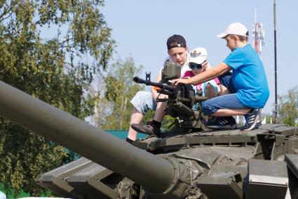 Московская область. Дети сидят на танке во время проведения международных соревнований `Танковый биатлон - 2018` на подмосковном полигоне `Алабино`.