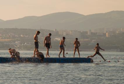 Геленджик. Мальчики прыгают с пирса в море.