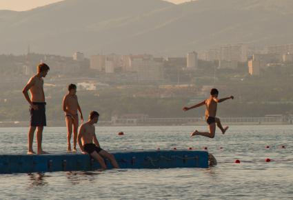 Геленджик. Мальчики прыгают с пирса в море.