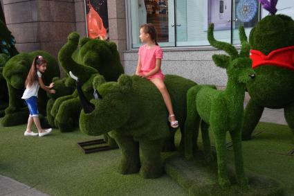 Москва. Дети фотографируются на зеленых фигурах.