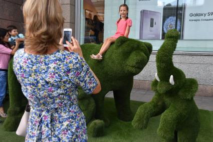 Москва. Дети фотографируются на зеленых фигурах.