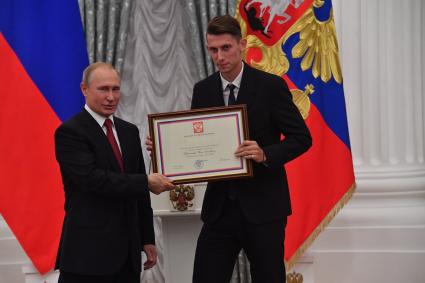 Москва. Президент РФ Владимир Путин и игрок сборной России по футболу Илья Кутепов (справа) на церемонии вручения государственных наград и почетных грамот игрокам и тренерам сборной России по футболу - участникам чемпионата мира по футболу - 2018 в Екатерининском зале Кремля.
