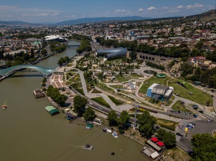 Грузия, Тбилиси.  Вид на пешеходный мост Мира через реку Кура и парк Рике.