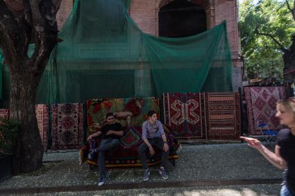Грузия. Тбилиси. Мужчины продают ковры.
