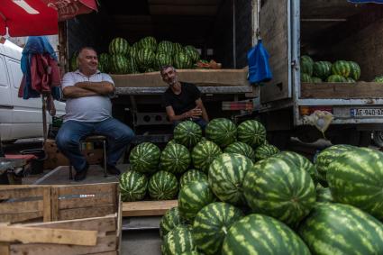 Грузия, Тбилиси.  Мужчины продают  арбузы на рынке.