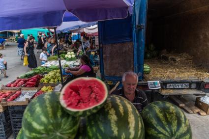Грузия, Тбилиси. Мужчина продает арбузы на рынке.