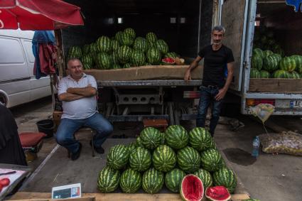 Грузия, Тбилиси.  Мужчины продают  арбузы на рынке.