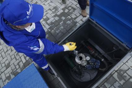 Екатеринбург. Оператор АЗС проверяет металлическим щупом наличие воды в топливном резервуаре на автозаправочной станции \'Газпромнефть\'