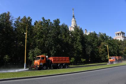 Москва. Поливальные машины возле здания МГУ имени М.В. Ломоносова на Воробьевых горах.