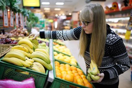 Ставрополь.  Девушка выбирает бананы в магазине.