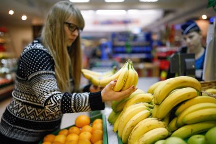 Ставрополь. Девушка выбирает бананы в магазине.