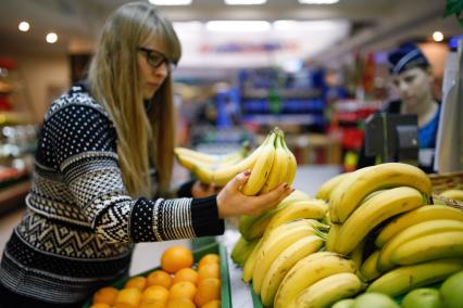 Ставрополь.  Девушка выбирает бананы в магазине.