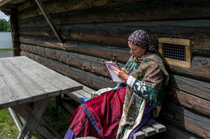 Республика Карелия. Кижи. Женщина в национальном костюме занимается вышивкой в музее-заповеднике на острове Кижи.