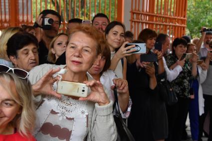 Москва. Родители фотографируют детей  после торжественной линейки, посвященной Дню знаний.