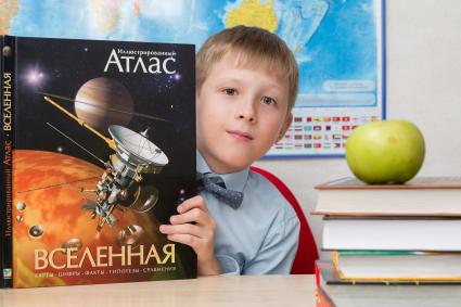 Челябинск. Мальчик с книгой `Иллюстрированный атлас. Вселенная`.