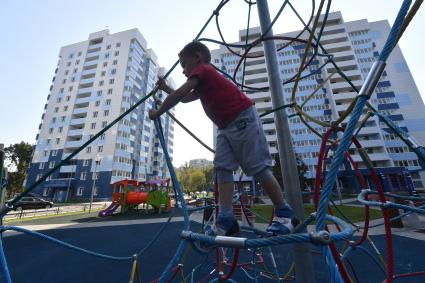 Москва. Мальчик играет на детской площадке во дворе  нового дома, построенного  по программе реновации на Судостроительной улице.