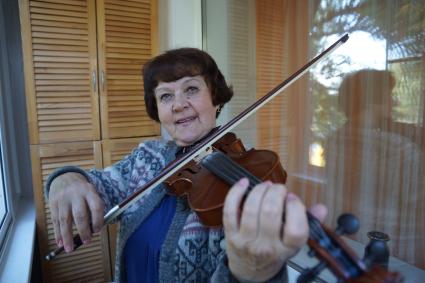 Самара. Женщина пенсионного возраста играет на скрипке.