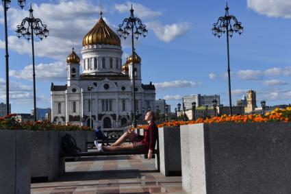 Москва. Девушка курит на скамейке Патриаршего моста.