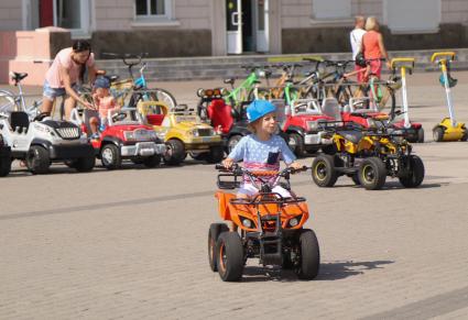 Новороссийск.   Мальчик катается на электроквадроцикле на Форумной площади.