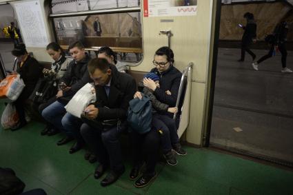 Москва. Пассажиры в вагоне поезда метро.