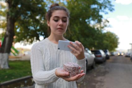 Красноярск.  Девушка держит в руке утилизированные банкноты.