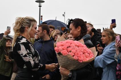 Москва. Телеведущая Ольга Бузова (справа) вручила ключи победительнице `гива` - девушке-блогеру.